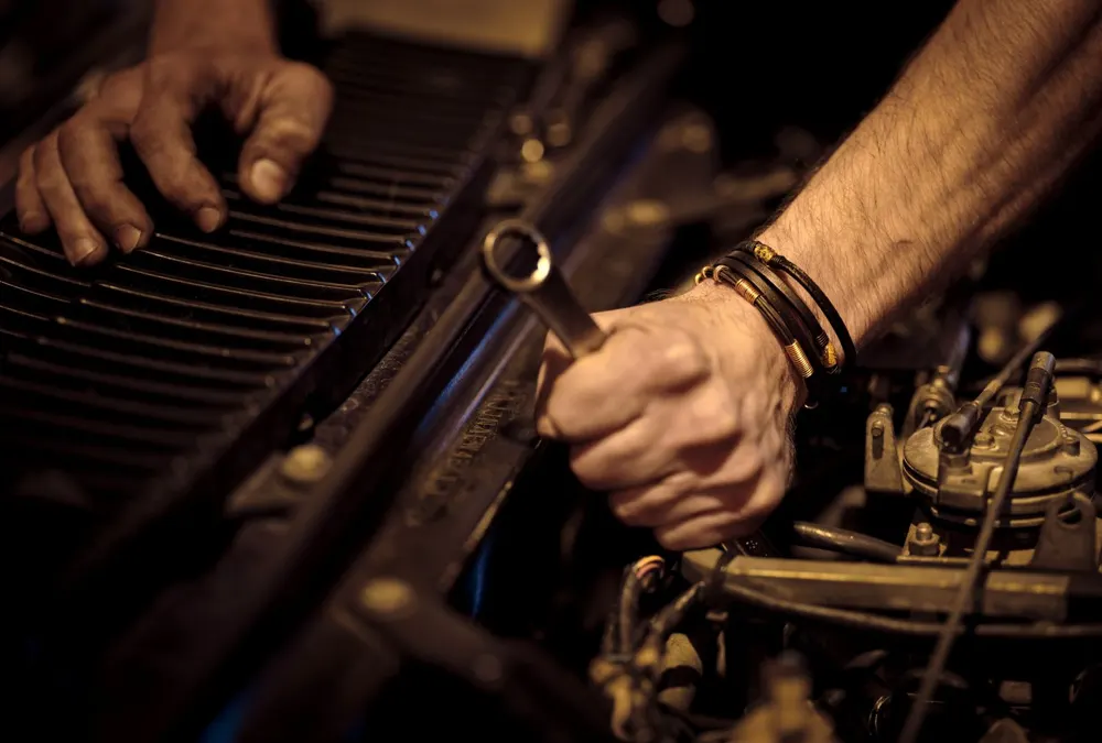Mechanic using a wrench on a car engine