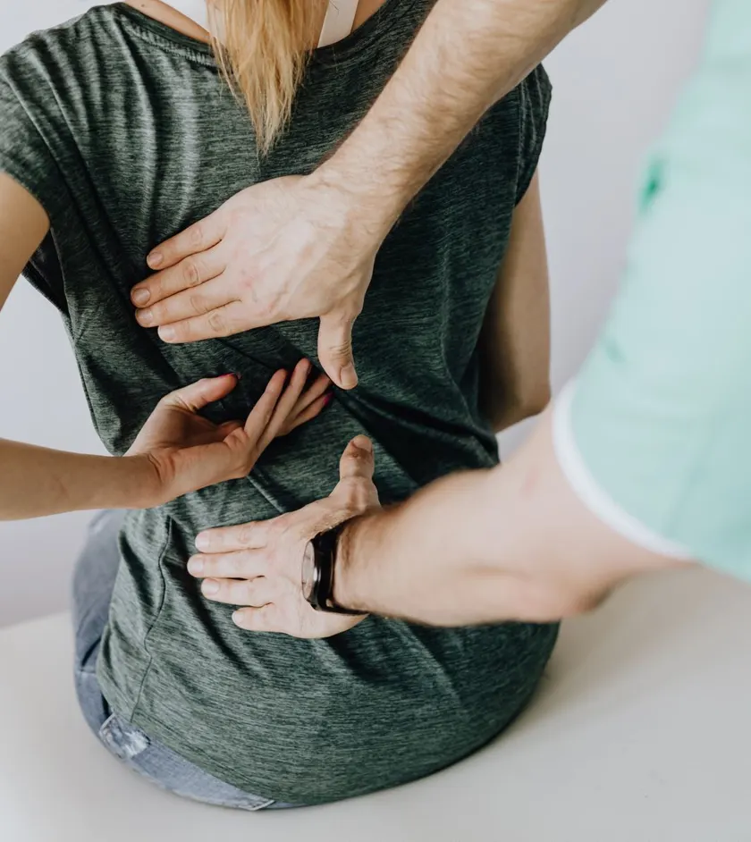 Chiropractor assessing a patient’s back