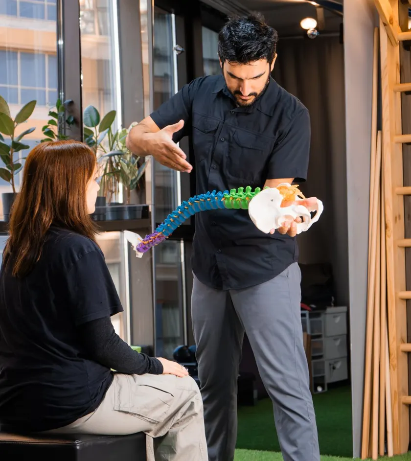 Chiropractor showing a patient a model of the spine
