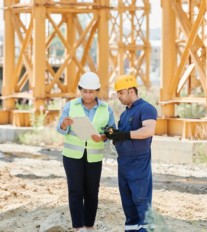 Site manager and worker reviewing plans on a construction site