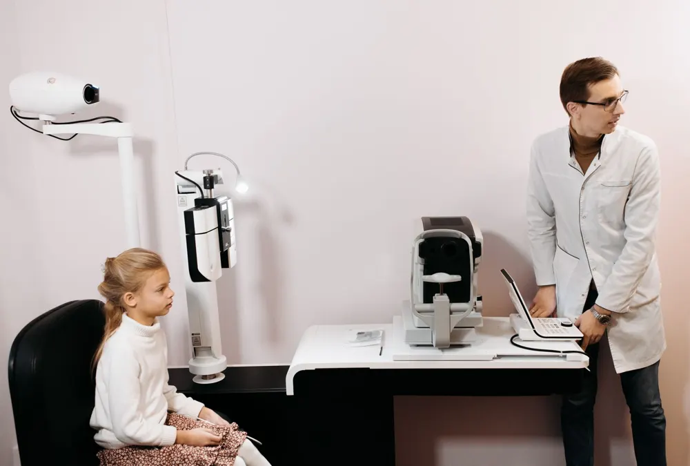 Eye doctor and young patient in an exam room