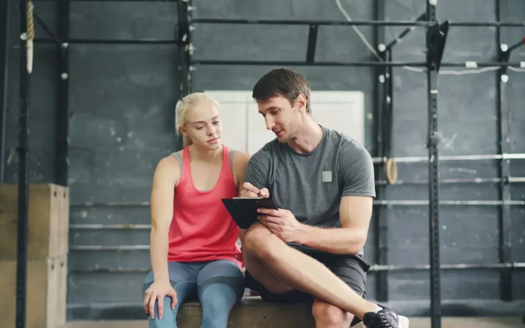 Trainer and client reviewing a fitness plan on a tablet