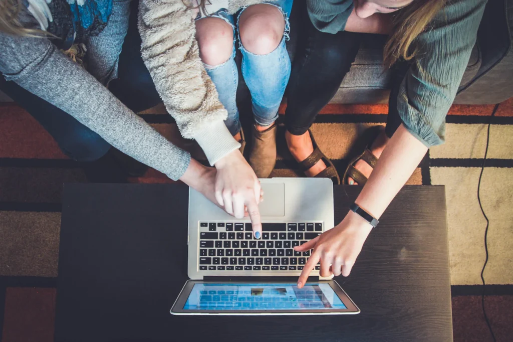 Team pointing at a laptop screen while launching a new Google Ads campaign
