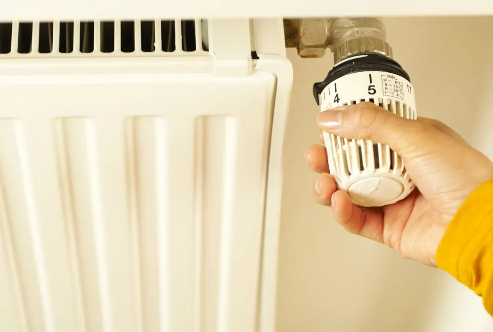 Hand adjusting a radiator thermostat valve