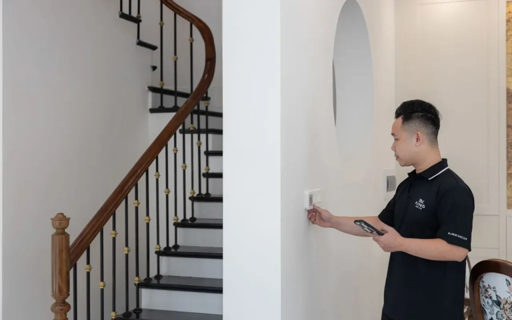 Technician checking a wall thermostat with a tablet in a home