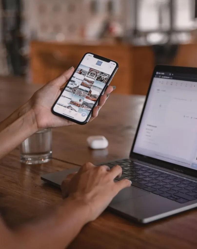 Person browsing a law firm website on a phone next to a laptop