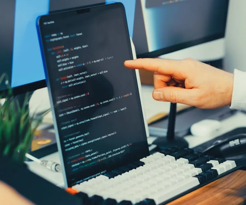 Developer pointing at website code on a screen