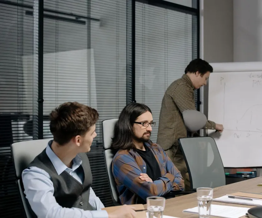 Team discussing a project plan at a whiteboard in a meeting room