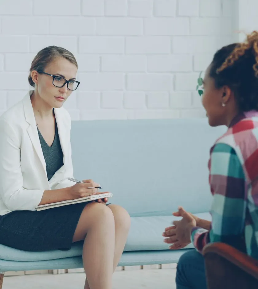 Therapist taking notes while talking with a client