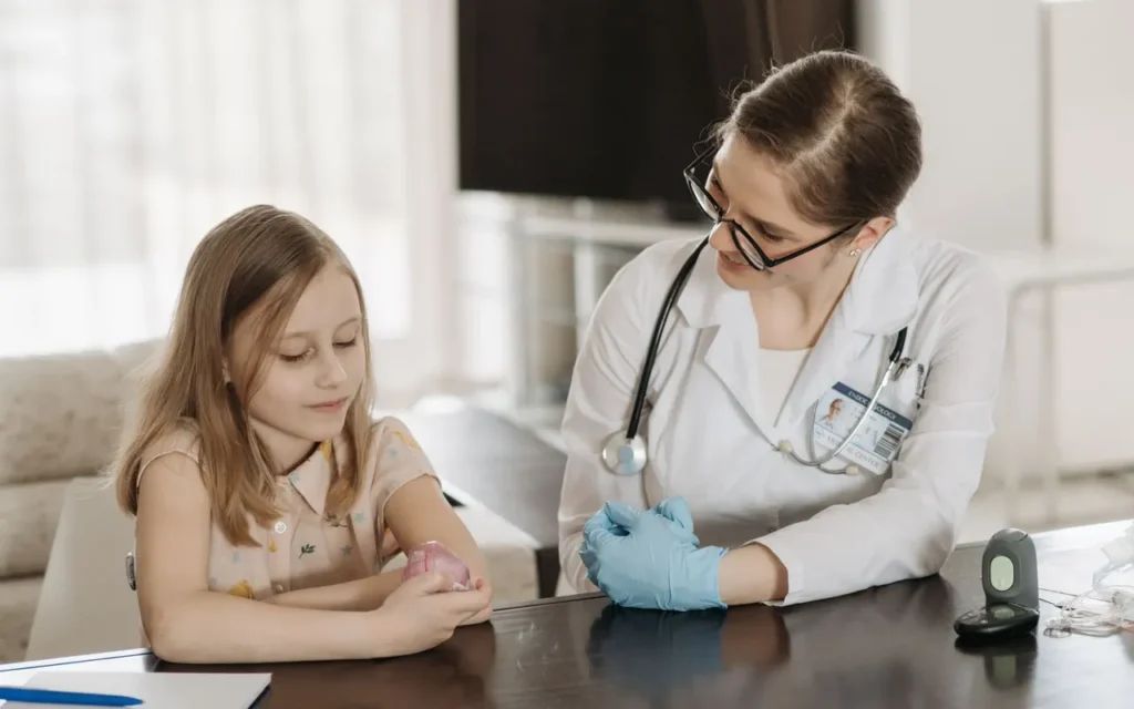 Pediatrician talking with a young patient at a desk