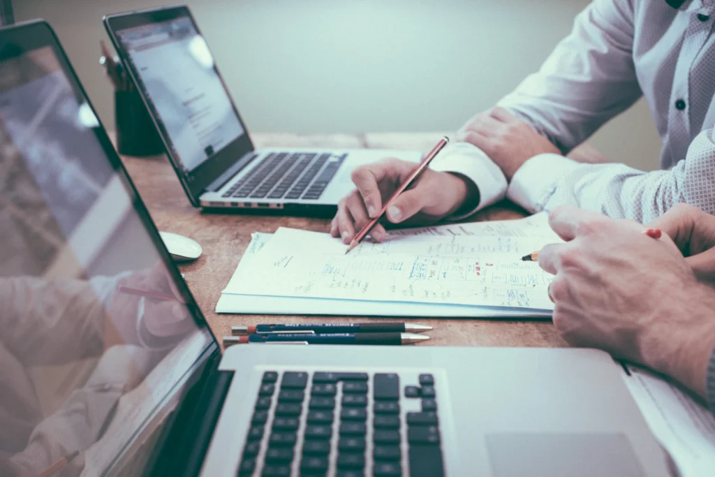 Marketer planning a Google Ads account audit with notes beside a laptop