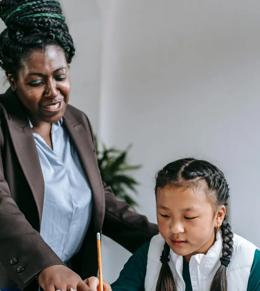 Teacher helping a young student with a lesson
