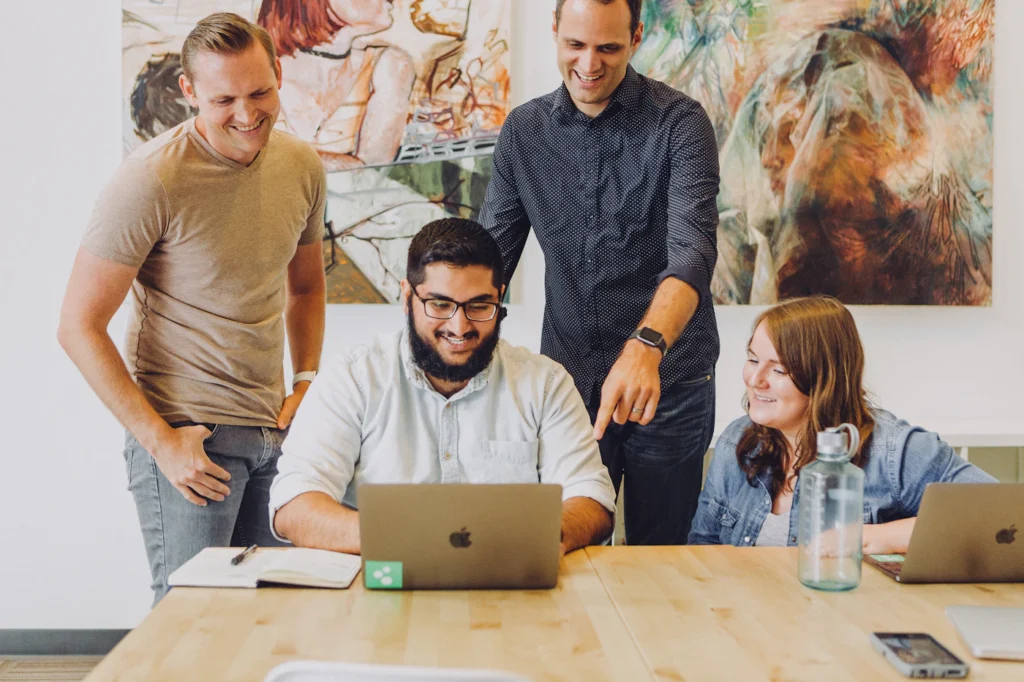 Small business team smiling while reviewing their new website design on a laptop